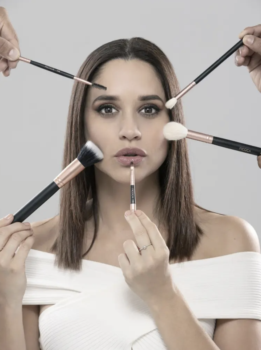 Andrea Navarrete rodeada de brochas profesionales de maquillaje